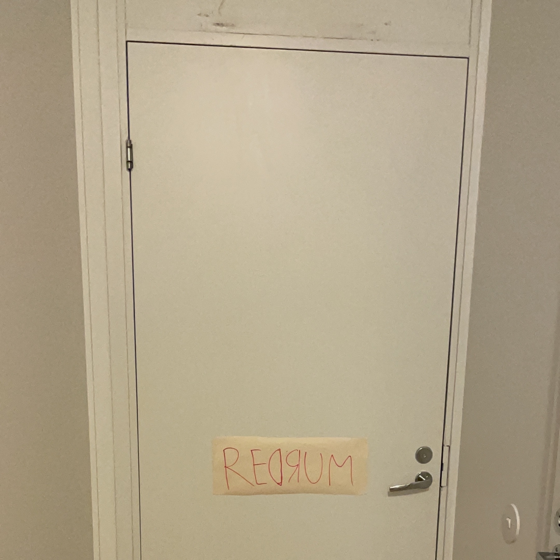 white door with a note in red "redrum"