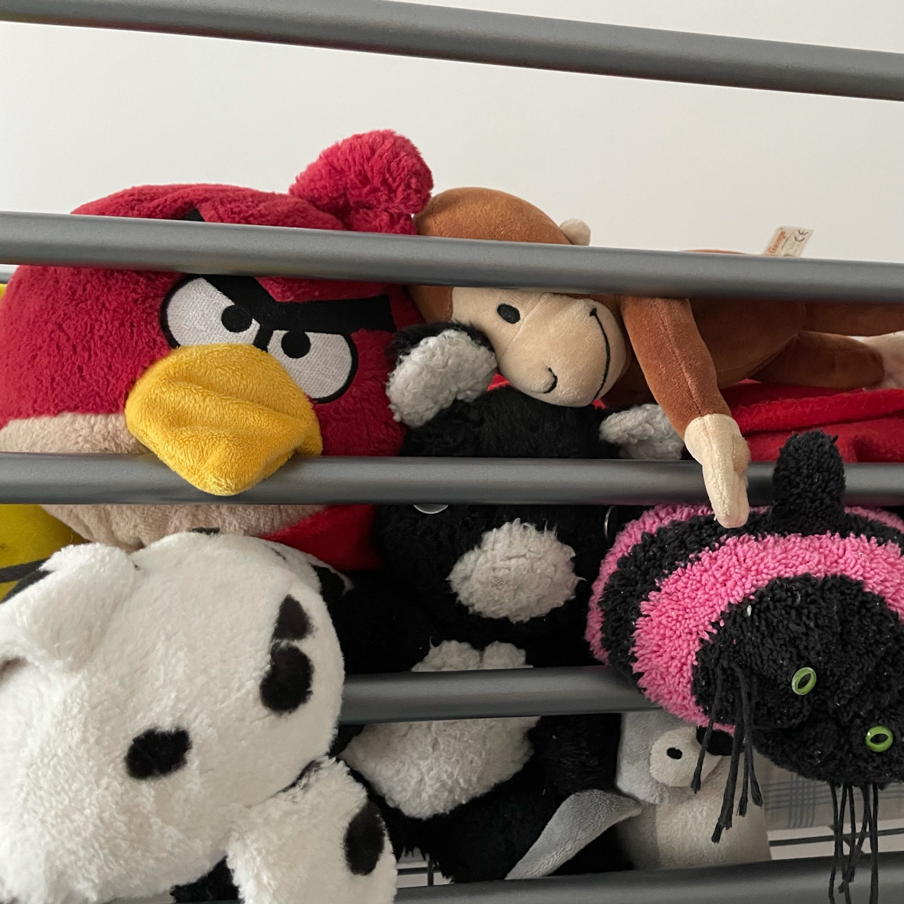 several teddy bears, dogs, monkey on a top bunk of a bunk bed