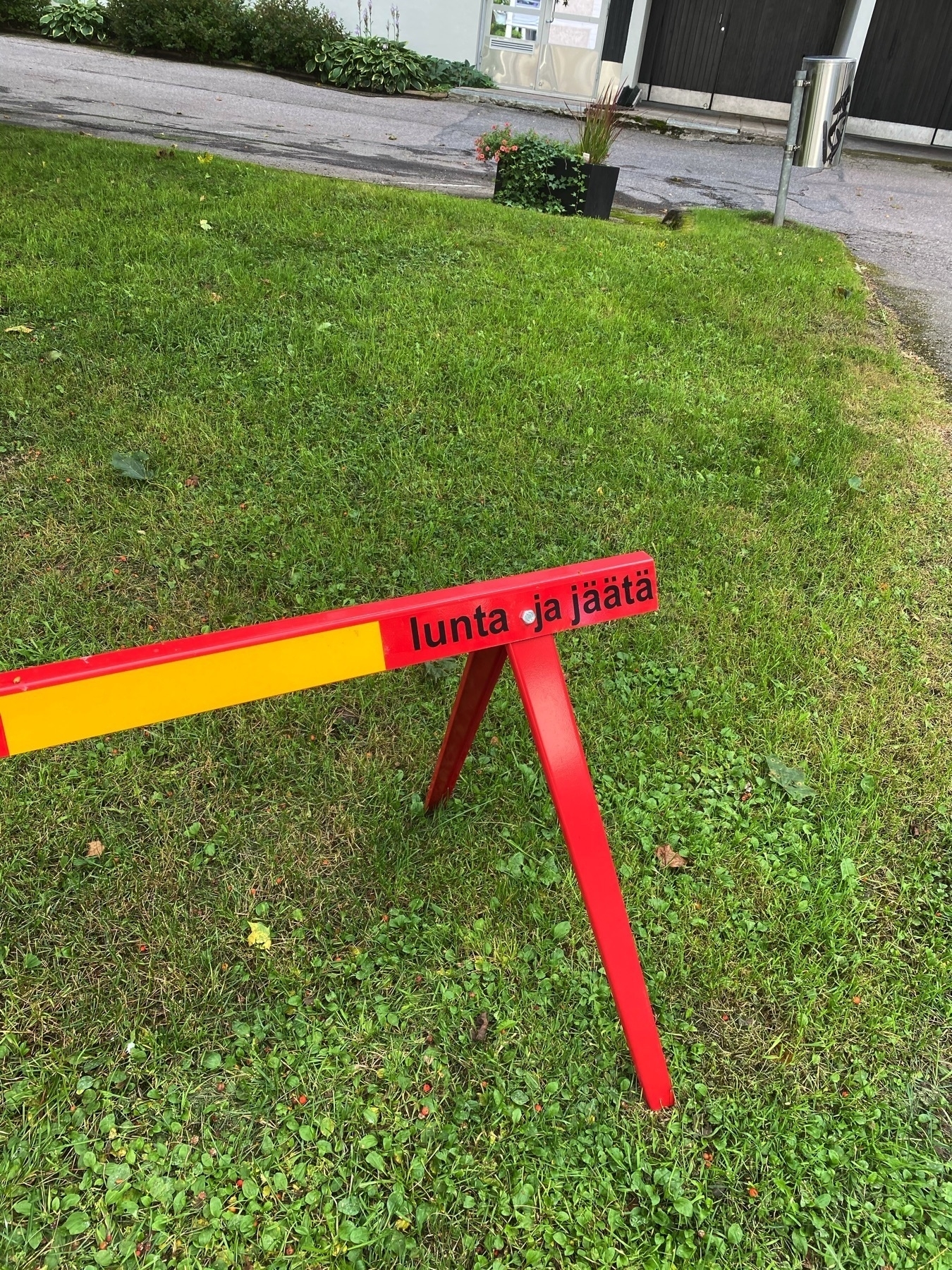 road block that says “snow and ice” in Finnish in the mid summer