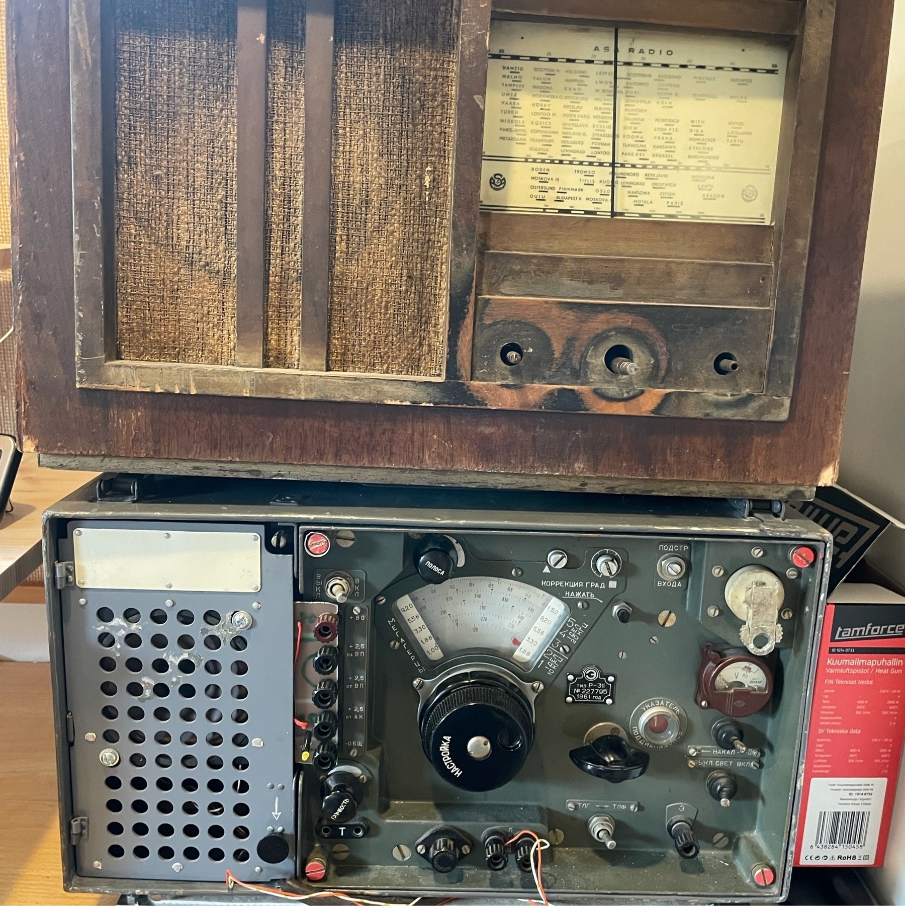 two old radios on top of each other, lower one with cyrillic texts in controllers