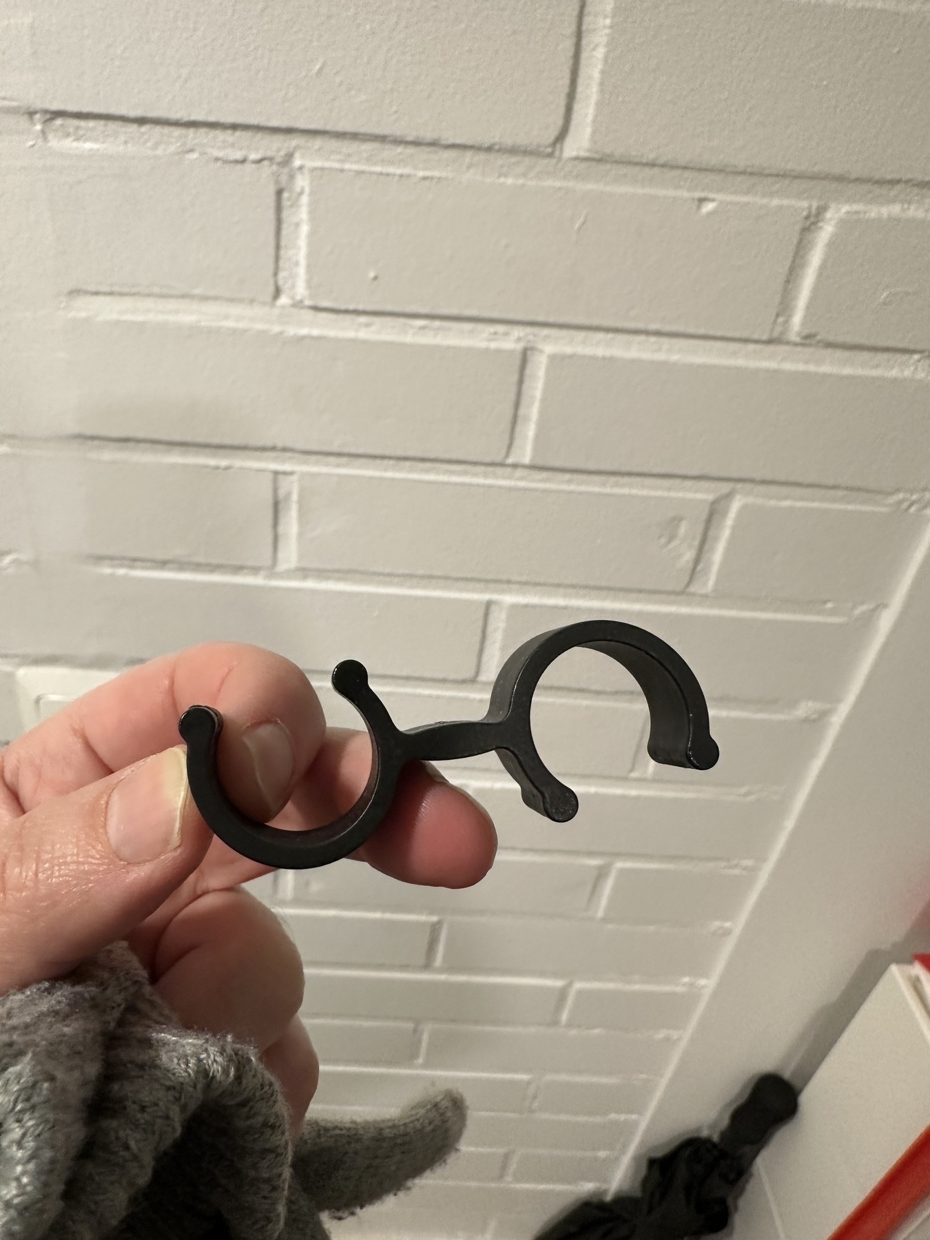 Plastic clip that consists of two plastic arcs that open up into opposing directions and are connected by a straight piece of plastic