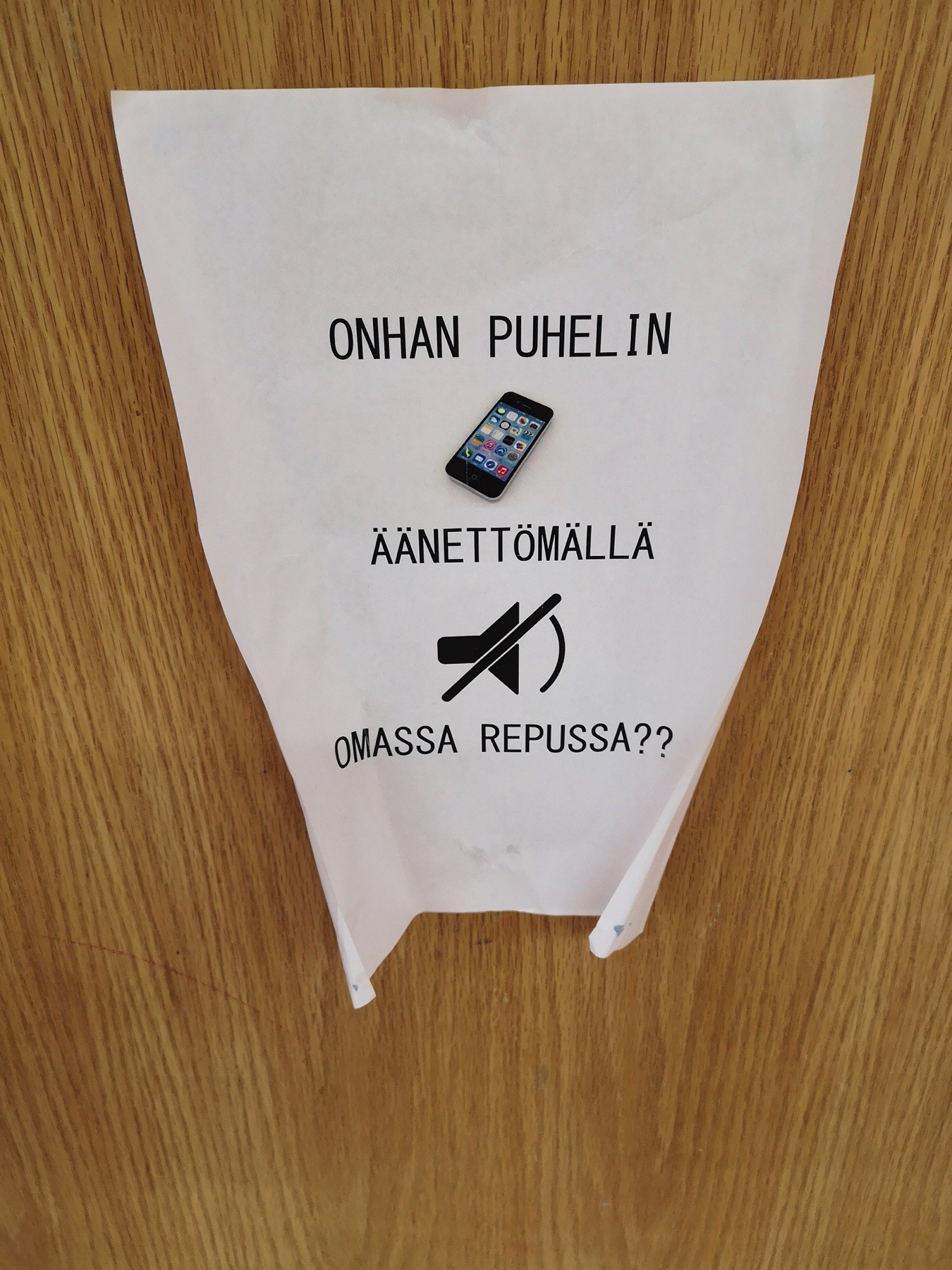 Piece of paper on a Finnish school door that says in Finnish: “keep your phones on silent and in your backbag, please”