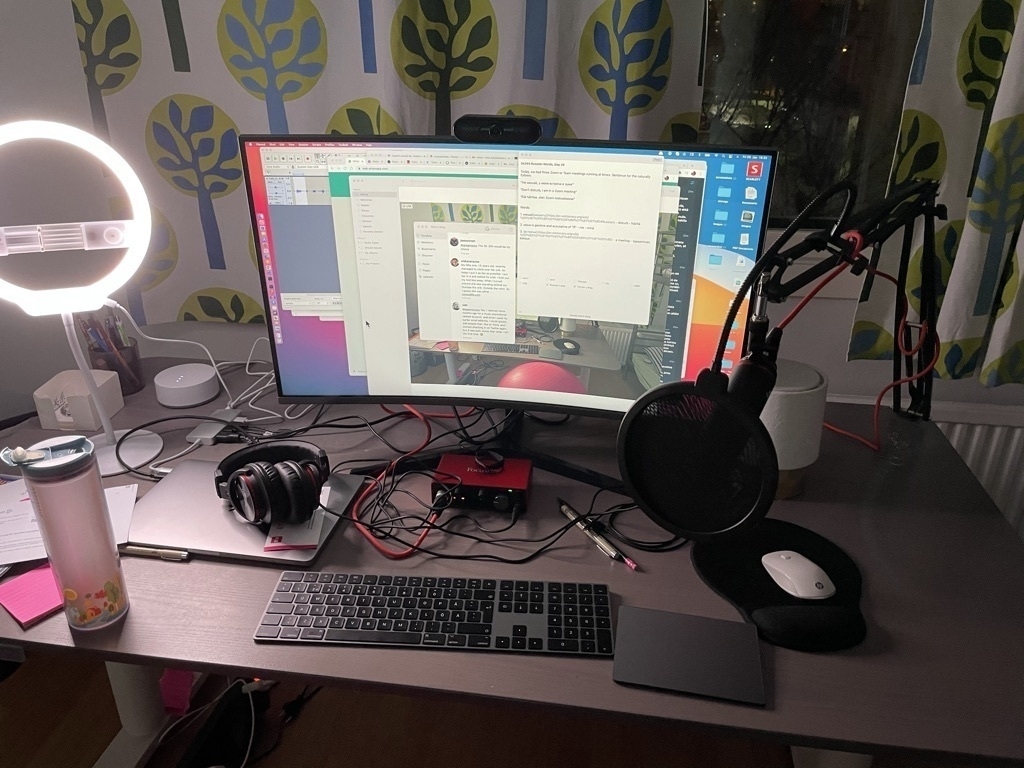 messy computer desk with boom microphone and micro.blog on screen