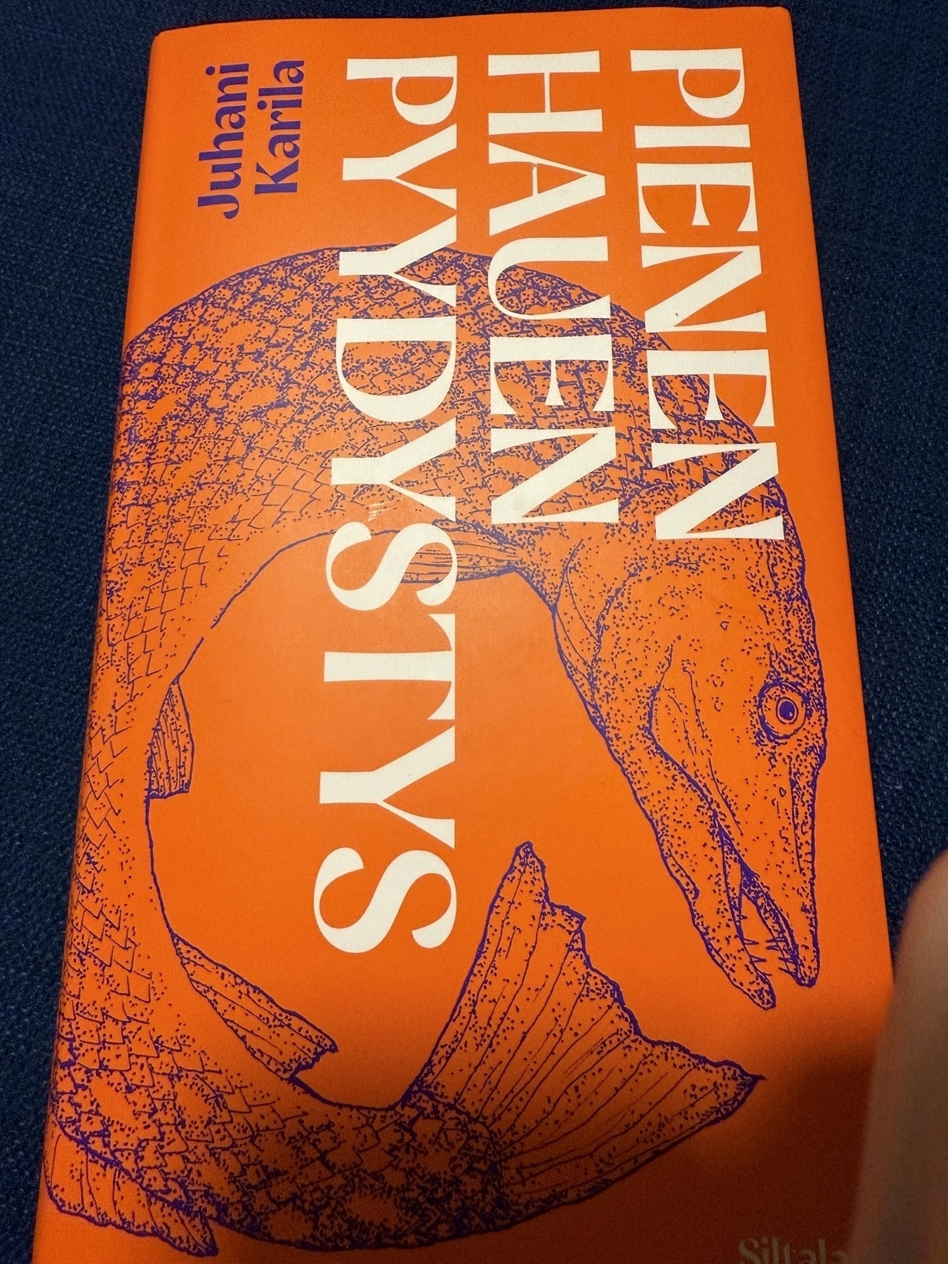Book by Juhani Karila: Pienen hauen pyydystys. Red book cover with a drawing of a pike fish on it
