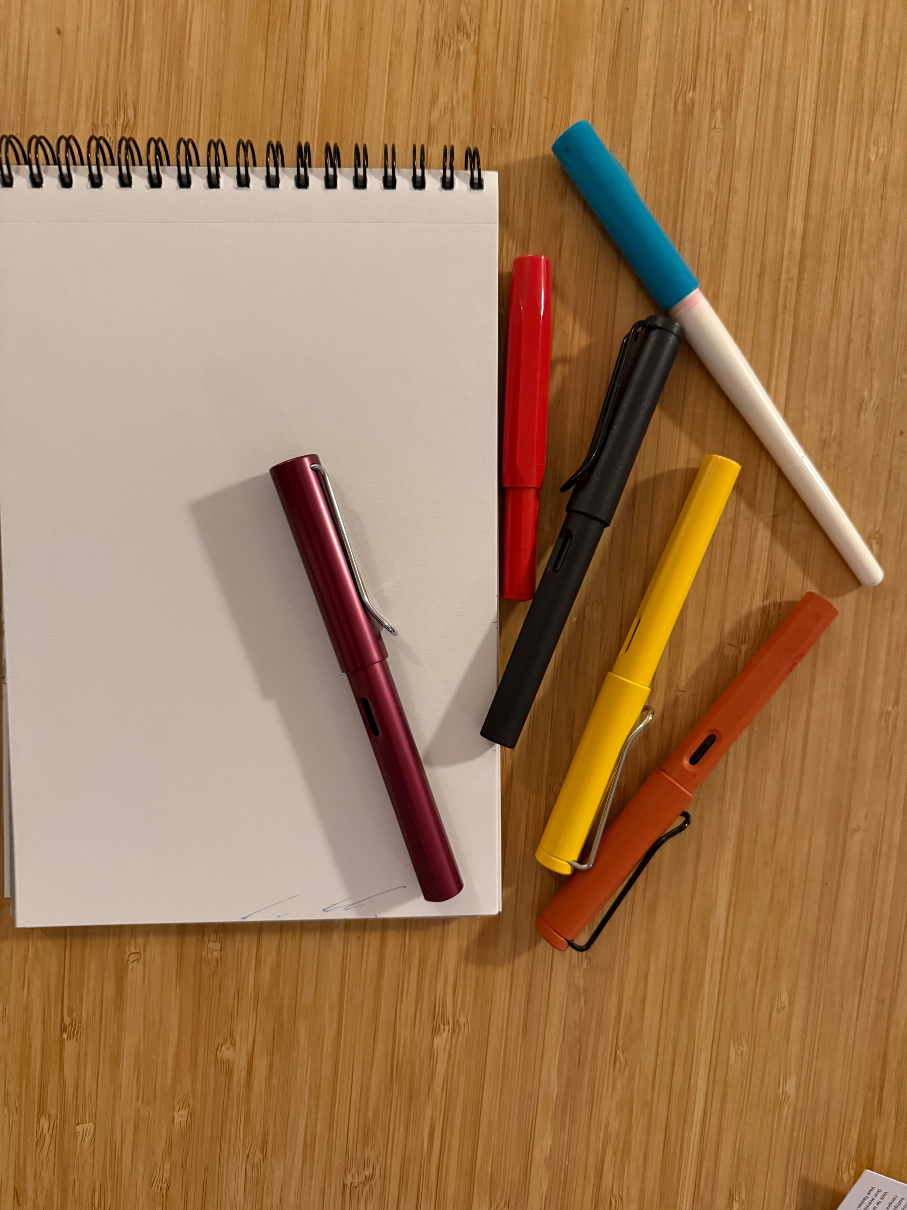 Empty page of a draft book. One Pilot Parallel, one Kaweco Sport and four Lamy Safari’s (one of them is really AL-star)